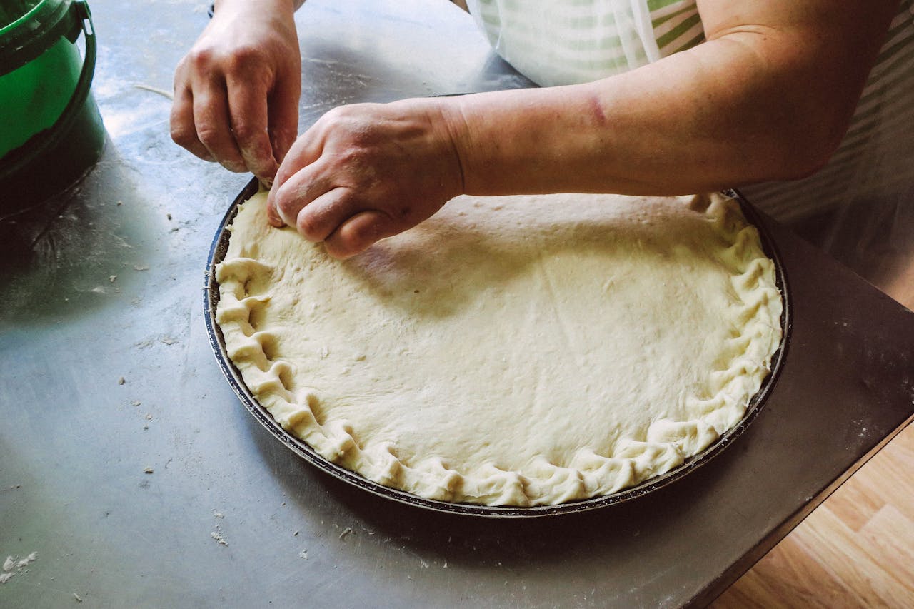 Crafting Captivating Headlines: Your awesome post title goes here Hands shaping pie dough on a baking tray, showcasing homemade food preparation.